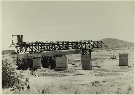 Kings Avenue Bridge under construction. View to west showing a pre-stressed concrete beam inside the steel gantry ready for lowering onto the piers.