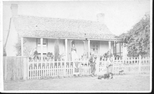 Elm Grove in Rutledge Street, Queanbeyan showing a man and woman and three small children in front of the house. Built 1862.