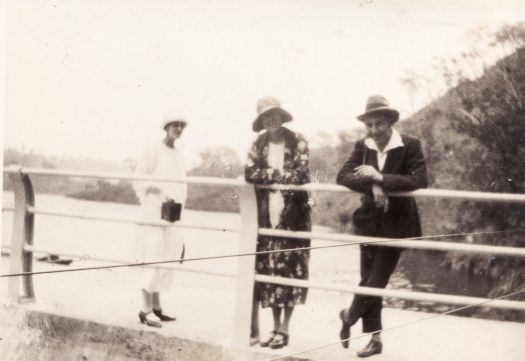 Two women and a man standing on what appears to be the top of the Cotter Dam wall.