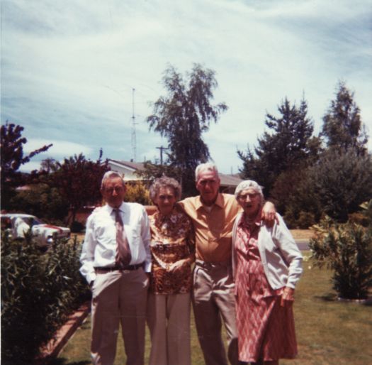 Colour photo of four friends -  2 couples - in front garden.