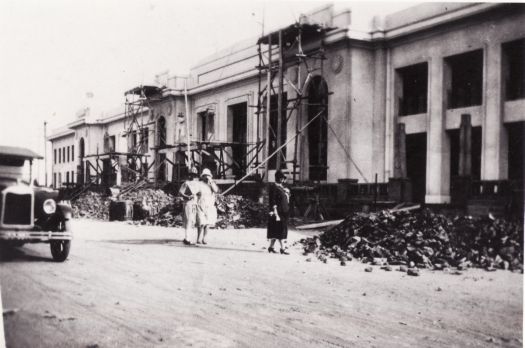 Parliament House, partly built with 3 ladies standing in front