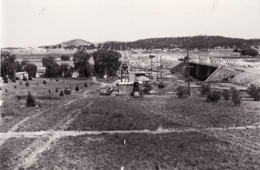 Construction of Commonwealth Avenue with the Hotel Canberra slightly to the right and Parliament House on the left.