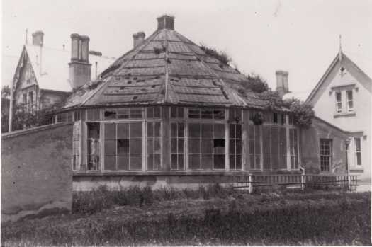 Duntroon House and conservatory. The conservatory is in disrepair with broken windows.