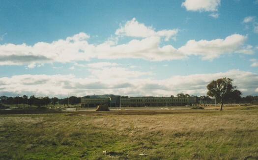 View across grassland north to Gungahlin Marketplace. Car park is in front of the shops.