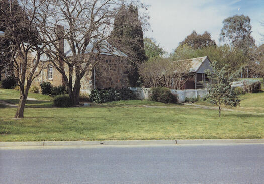 Side view of Blundell's Cottage with Wendouree Drive in the foreground.