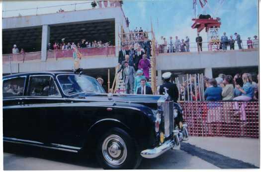 Prince and Princess of Wales walking down temporary stairs towards their Rolls Royce